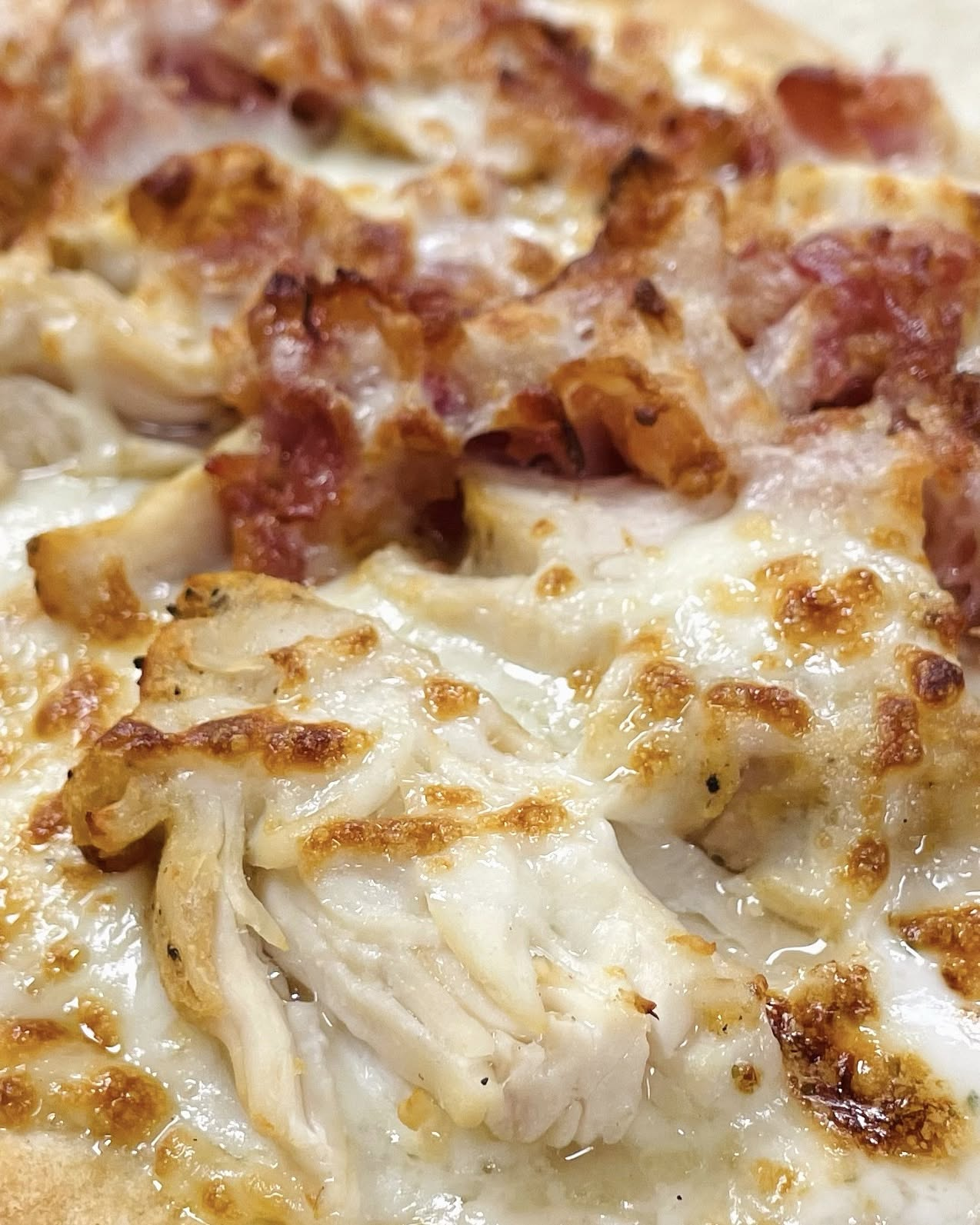Order at Cravin’ Market & Deli chicken bacon and melted cheese on pizza